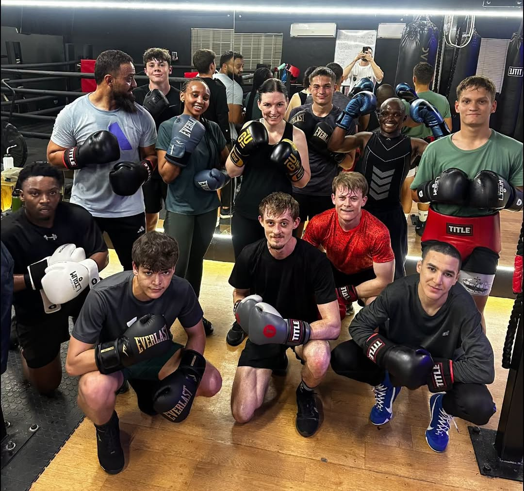 El Tigre boxing class group photo with gloves raised