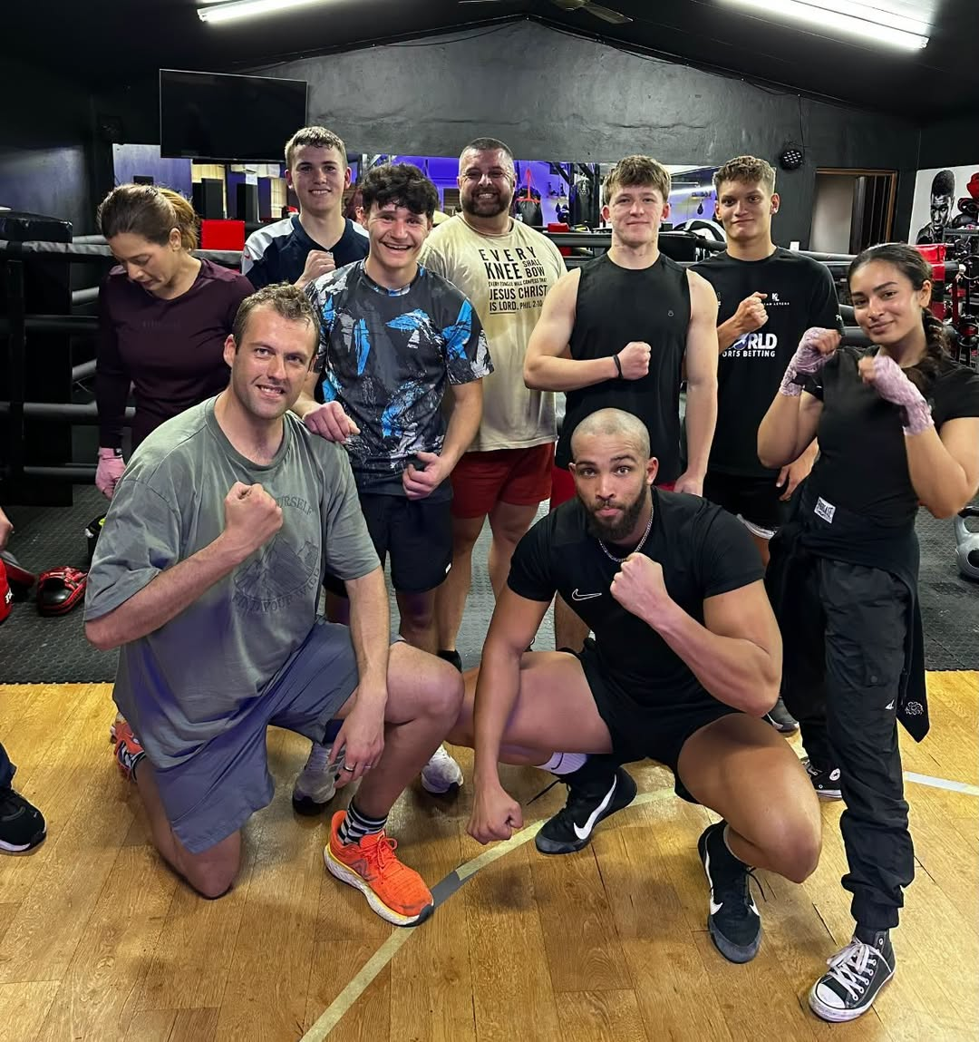 Mixed group of members posing in the gym