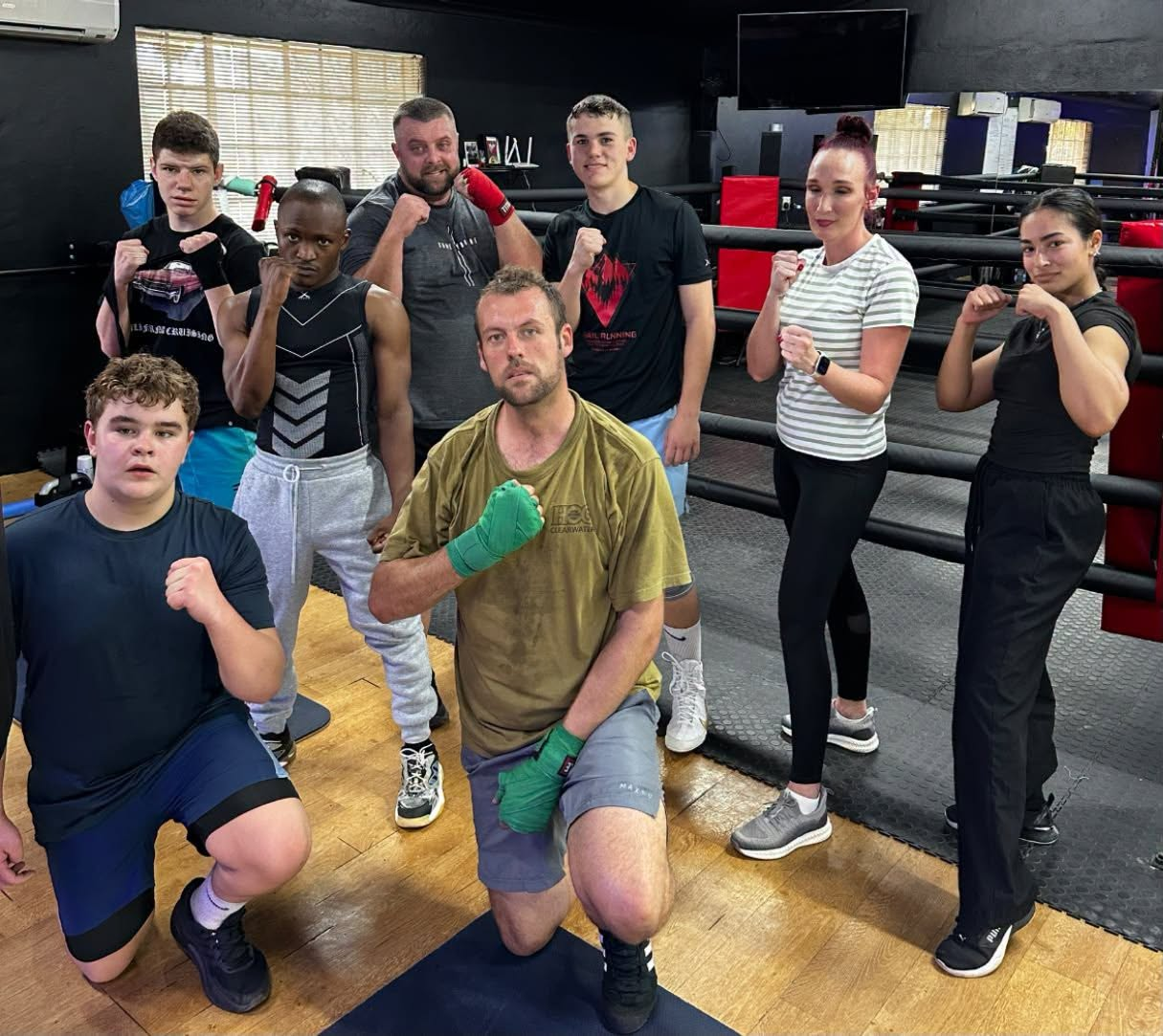 Members in fighting stance beside the boxing ring